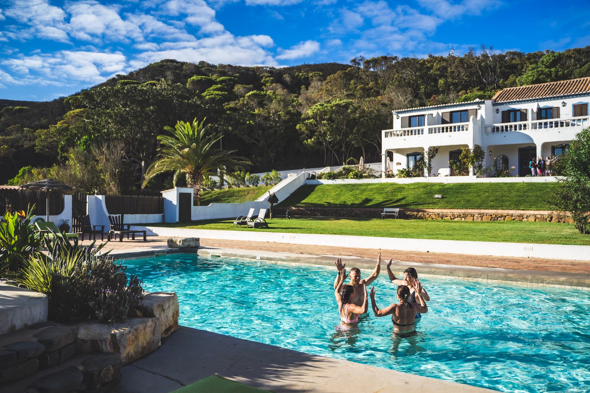 Nach einem gelungenen Workout erholen sich die Teilnehmenden eines Fitness Retreats im Pool