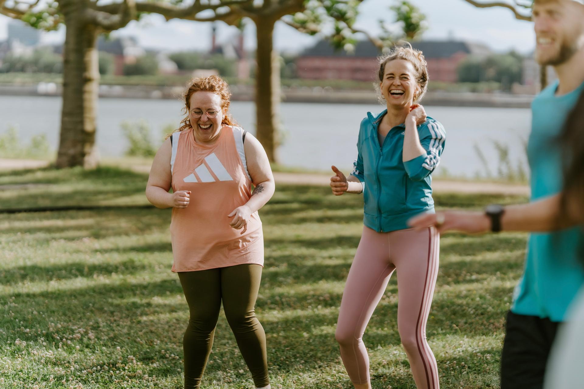 Zwei Frauen lachen gemeinsam im Outdoor Fitness Bootcamp