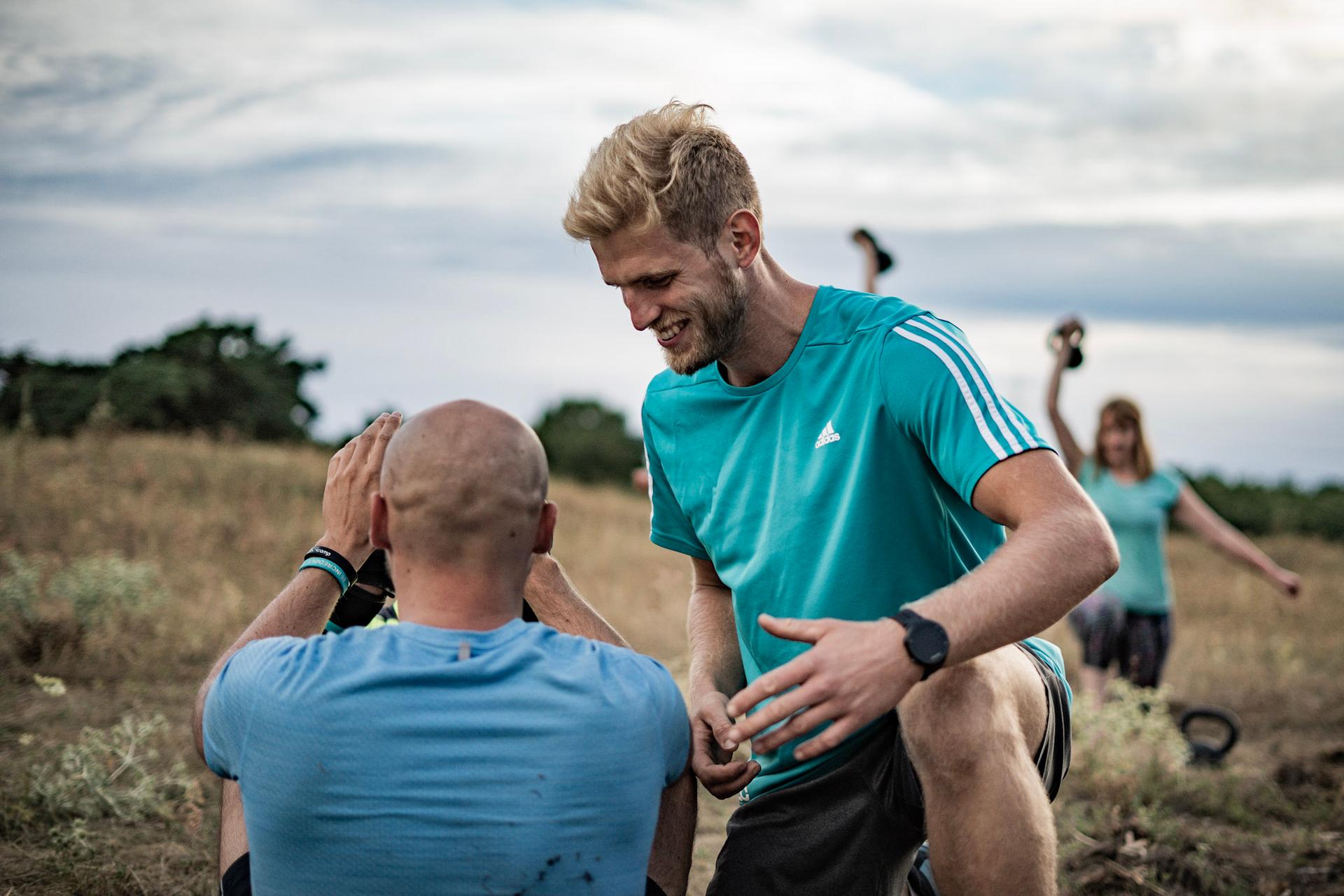 Trainer gibt Hilfestellung bei Sit-Ups