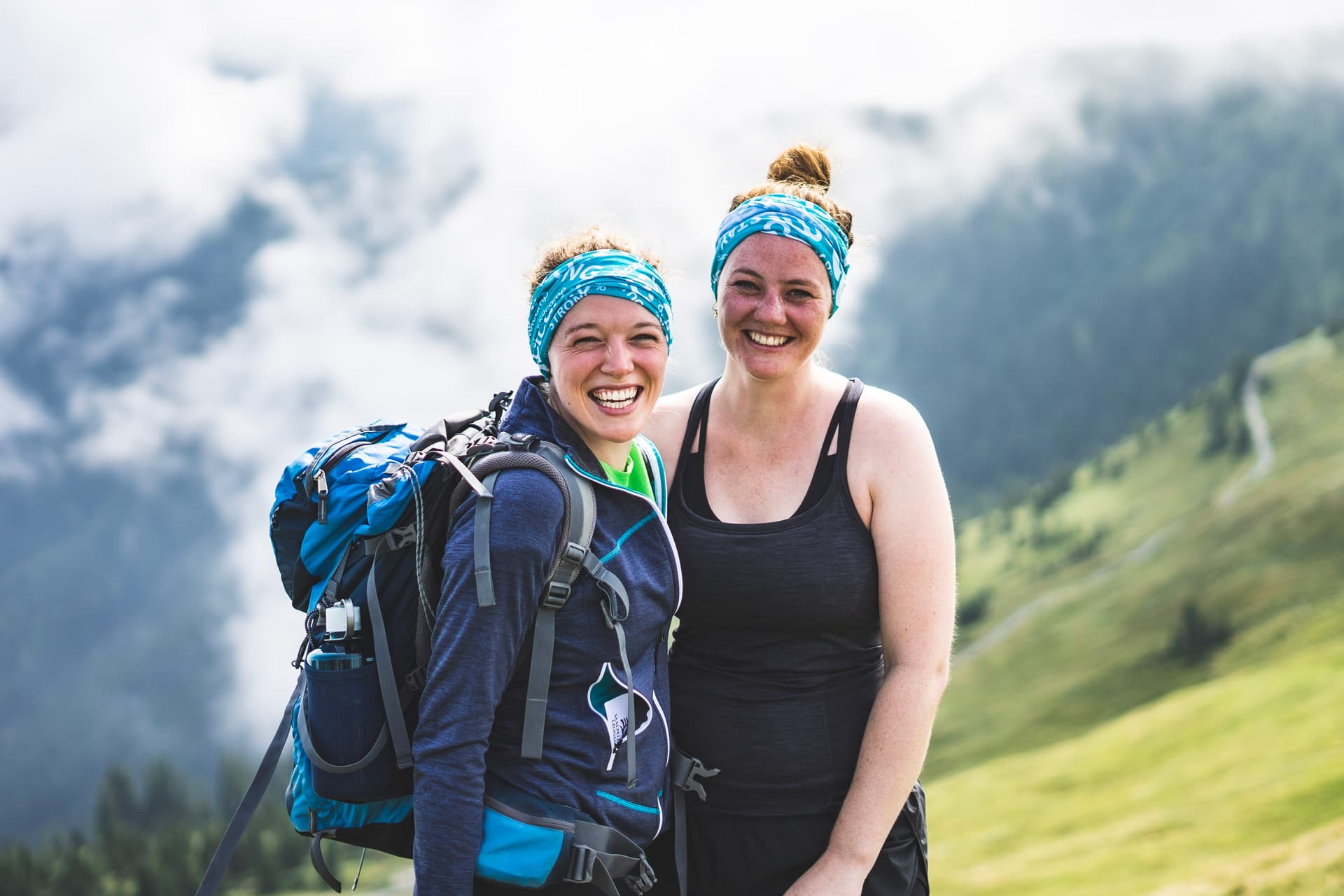 2 Frauen mit Rucksack und Sportklamotten in den Bergen