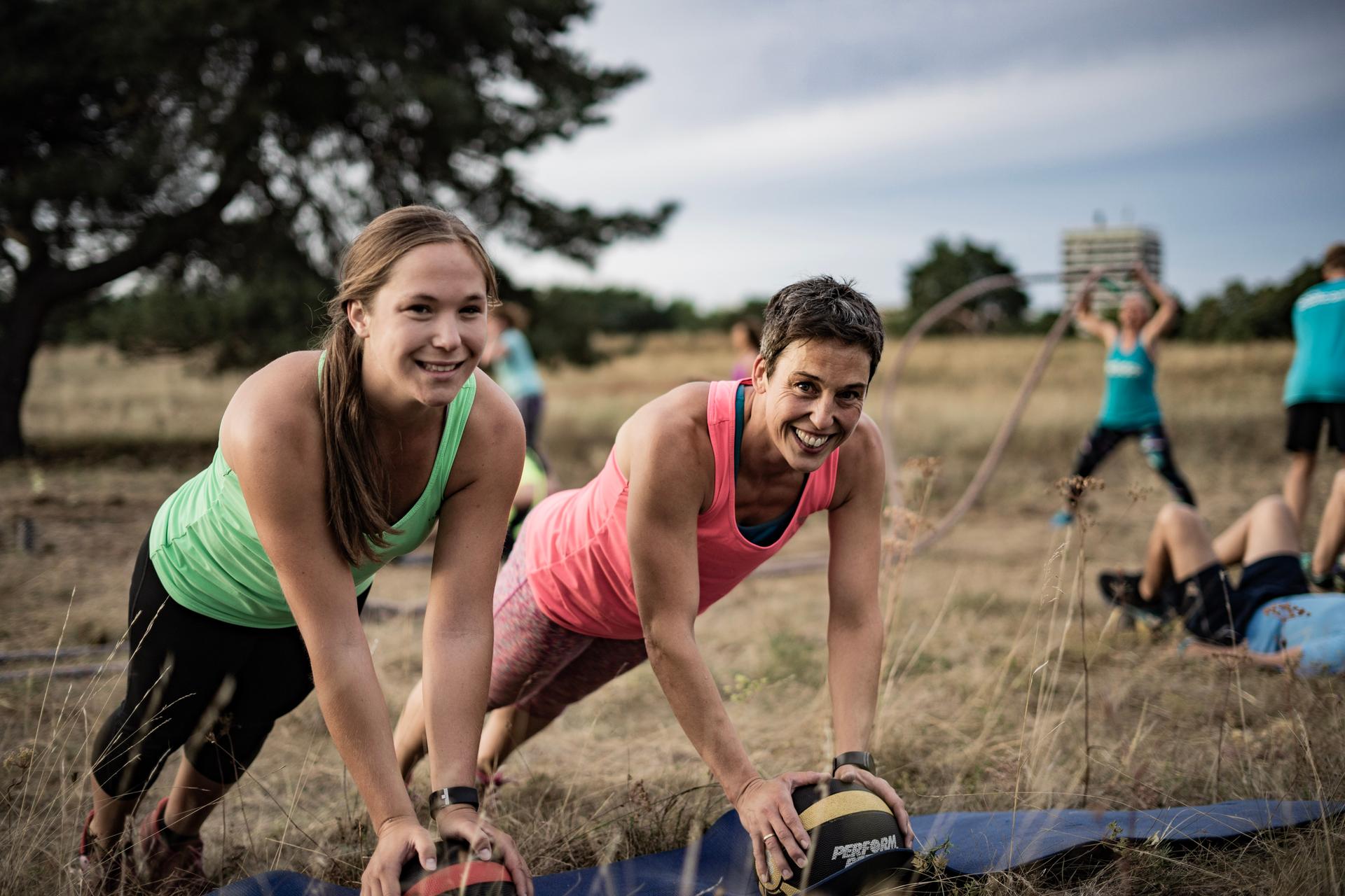 Frauen beim Training mit Medizinbällen beim bootcamp outdoor fitness training